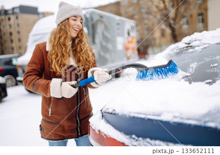 Cleaning snow from a car. Transport concept, seasonality Winter glass cleaning. Cleaning snow from a car. Transport concept, seasonality Winter glass cleaning. 133652111