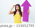 Woman in a yellow tank top holding a purple sign that says "up" 133652795