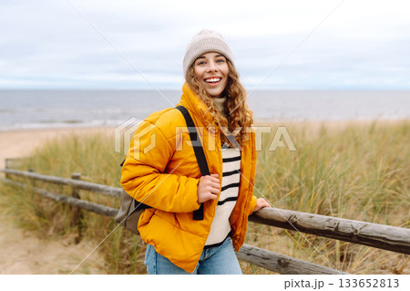 Attractive woman on a windy cold beach. Travel, nature concept. Attractive woman on a windy cold beach. Travel, nature concept. 133652813