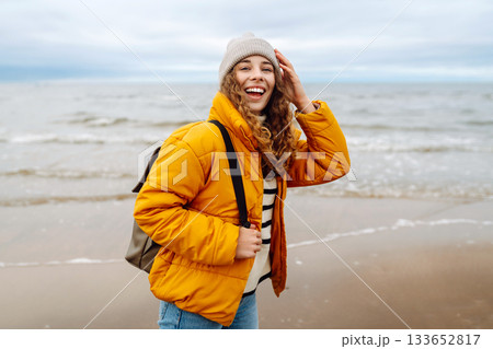 Attractive woman on a windy cold beach. Travel, nature concept. Attractive woman on a windy cold beach. Travel, nature concept. 133652817