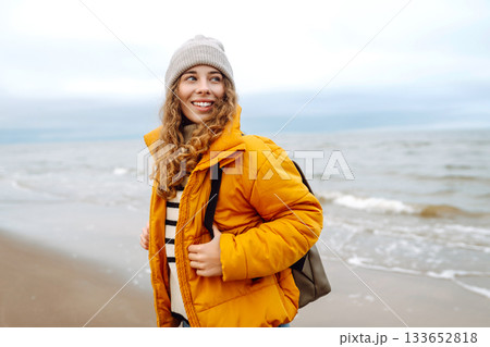 Attractive woman on a windy cold beach. Travel, nature concept. Attractive woman on a windy cold beach. Travel, nature concept. 133652818