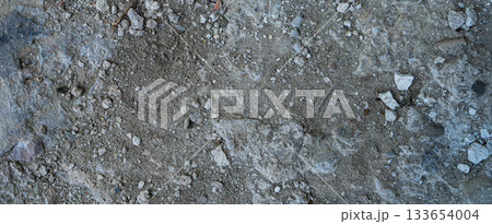 Close-up of a gray-black lava texture on the ground. Porous, cracked, and stony, perfect as a stock texture or photo background. Impression of molten rock. 133654004