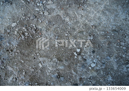 Close-up of a gray-black lava texture on the ground. Porous, cracked, and stony, perfect as a stock texture or photo background. Impression of molten rock. 133654009