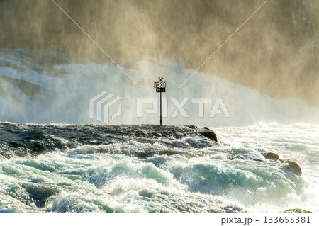 ラインの滝の中央の岩にある1880年と1963年の歴史的な水位マーカー。スイス、シャフハウゼン州ノイ ラインの滝の中央の岩にある1880年と1963年の歴史的な水位マーカー。スイス、シャフハウゼン州ノイ 133655381