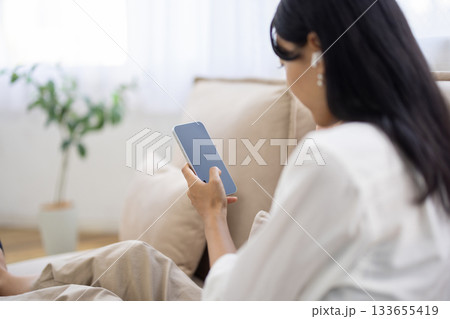スマートフォンを操作する女性の後ろ姿 133655419