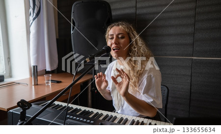 Caucasian woman singing into microphone in music studio. Caucasian woman singing into microphone in music studio. 133655634