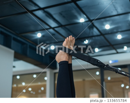 Caucasian woman doing exercises on reformer machine.  133655784