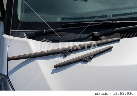 Windscreen wipers lying on the hood. Seasonal replacement.  133655930