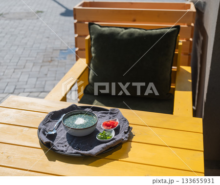 Traditional Russian lunch in a cafe. Top view of okroshka on a table in a summer cafe. Traditional Russian lunch in a cafe. Top view of okroshka on a table in a summer cafe. 133655931