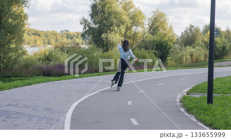 Caucasian woman roller skating in park.  133655999