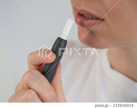 Woman smoking tobacco heating system. Electronic cigarette. Woman smoking tobacco heating system. Electronic cigarette. 133656018