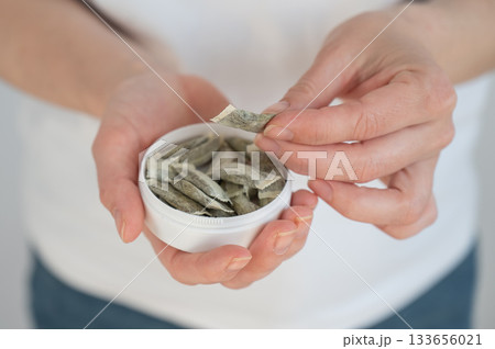 A woman holds a jar of chewing tobacco. A woman holds a jar of chewing tobacco. 133656021