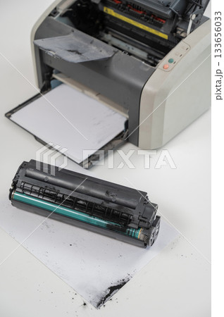 Broken laser printer cartridge on white background.  133656033