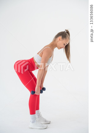 Young woman doing exercise with dumbbells on white background. Young woman doing exercise with dumbbells on white background. 133656086
