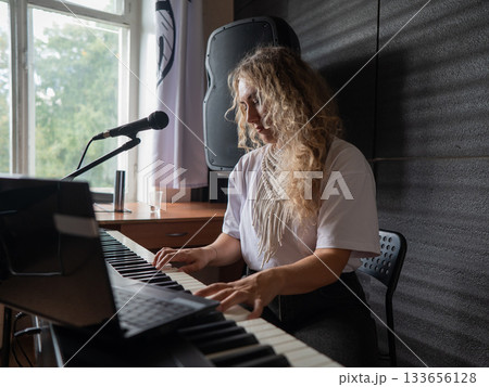 Caucasian woman singing into microphone and playing synthesizer.  133656128
