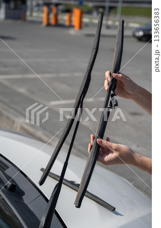 Close up of female hands changing windshield wipers. Close up of female hands changing windshield wipers. 133656383