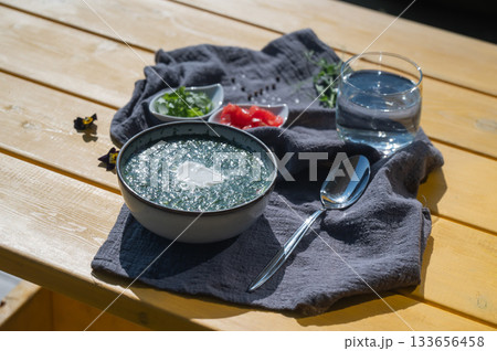 Traditional Russian lunch in a cafe. Top view of okroshka on a table in a summer cafe. Traditional Russian lunch in a cafe. Top view of okroshka on a table in a summer cafe. 133656458