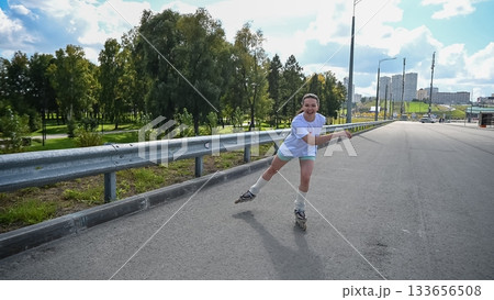 Caucasian woman rollerblading fast on road.  133656508