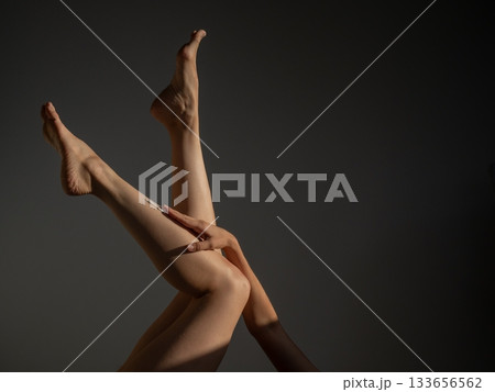 Woman applying moisturizer to her legs. Woman applying moisturizer to her legs. 133656562