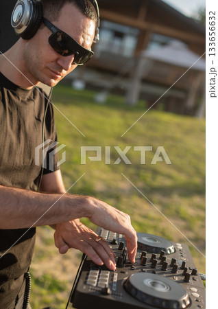 DJ works in the backyard of a country house. DJ works in the backyard of a country house. 133656632