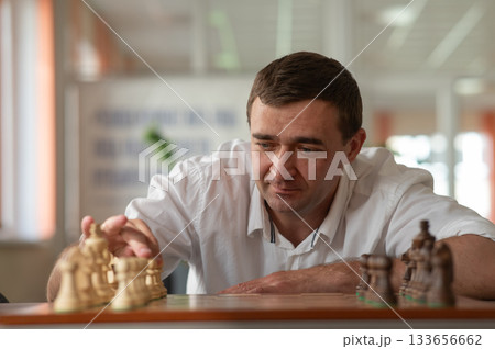 Middle aged Caucasian man playing chess. Middle aged Caucasian man playing chess. 133656662