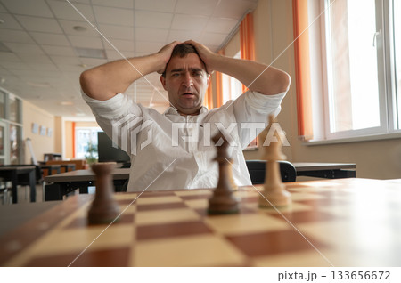 Middle aged Caucasian man playing chess. Middle aged Caucasian man playing chess. 133656672