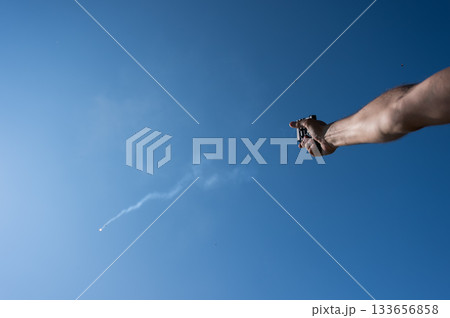 A man fires a flare gun with emergency fire. A man fires a flare gun with emergency fire. 133656858