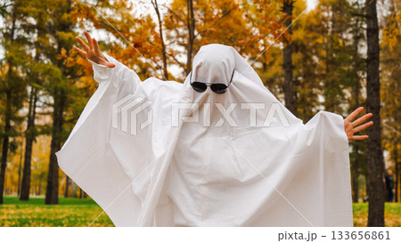 Woman in a ghost costume against the backdrop of an autumn forest. Halloween costume. Woman in a ghost costume against the backdrop of an autumn forest. Halloween costume. 133656861