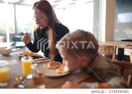 Woman and boy enjoying morning family breakfast meal 133656880