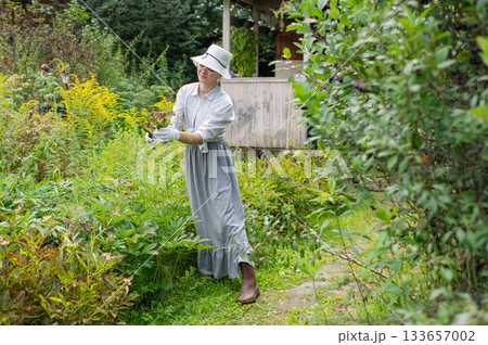 Young Caucasian woman trimming bushes.  133657002