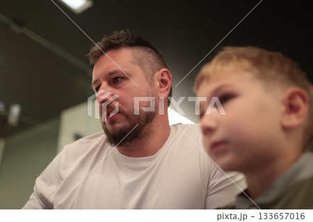 Father and son bonding while watching an event Father and son bonding while watching an event 133657016