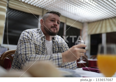 Man enjoying red wine and relaxed dinner at restaurant Man enjoying red wine and relaxed dinner at restaurant 133657087