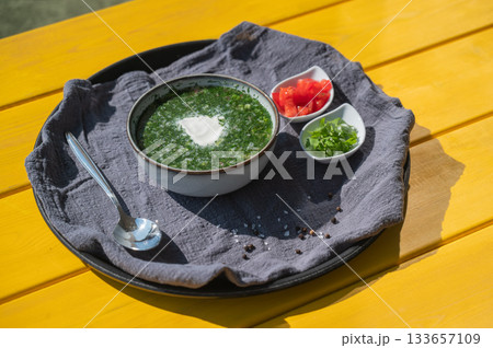 Traditional Russian lunch in a cafe. Top view of okroshka on a table in a summer cafe.  133657109