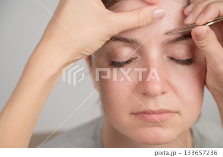 Caucasian woman undergoing eyebrow correction procedure. Caucasian woman undergoing eyebrow correction procedure. 133657236