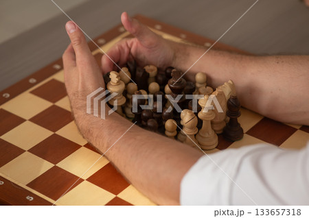 Close up of hands of middle aged caucasian man playing chess. Close up of hands of middle aged caucasian man playing chess. 133657318