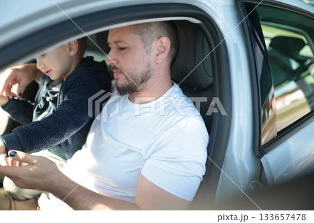Father and son traveling together in car interior 133657478