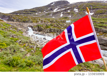 Norwegian flag and camper car in mountains Norwegian flag and camper car in mountains 133658909
