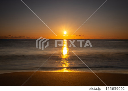 河原子海岸の冬の朝日と海面に伸びる黄金の光の道（茨城県） 133659092