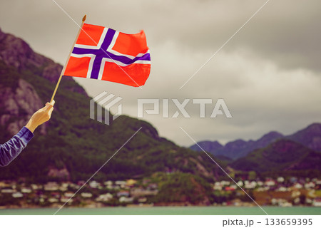 Tourist with norwegian flag on fjord Tourist with norwegian flag on fjord 133659395