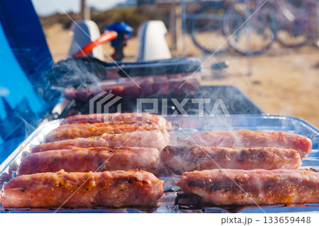 Sausages meat grilling on gas grill 133659448