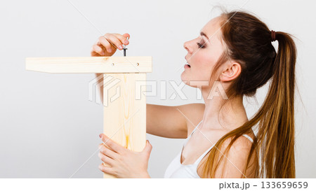 Woman assembling wooden furniture. DIY. Woman assembling wooden furniture. DIY. 133659659