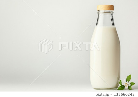 Classic glass milk bottle with vintage cap in minimalist design set against a clean white background 133660245
