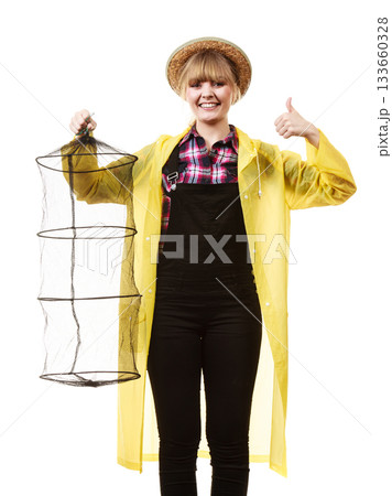 Happy woman holding empty fishing keepnet Happy woman holding empty fishing keepnet 133660328
