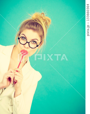 Happy woman holding fake lips on stick 133660364