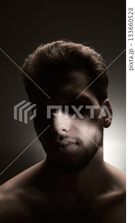 Dramatic portrait of man with post-procedure nose bandage in focused side lighting 133660528