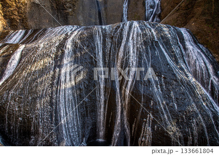 冬の袋田の滝・岩肌を流れる繊細な白線模様の水のアート 133661804