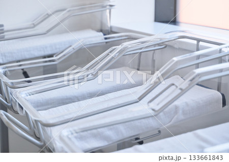 Empty hospital cribs arranged neatly in a bright nursery during the day Empty hospital cribs arranged neatly in a bright nursery during the day 133661843