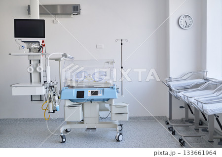 Neonatal care unit with incubator and medical equipment in a clean hospital room setup Neonatal care unit with incubator and medical equipment in a clean hospital room setup 133661964