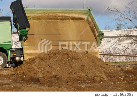 Dump truck unloading soil on construction site Dump truck unloading soil on construction site 133662088