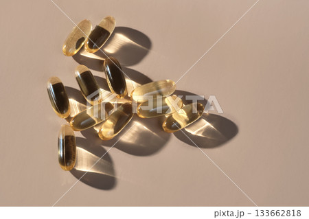 Golden omega 3 capsules in direct sunlight 133662818